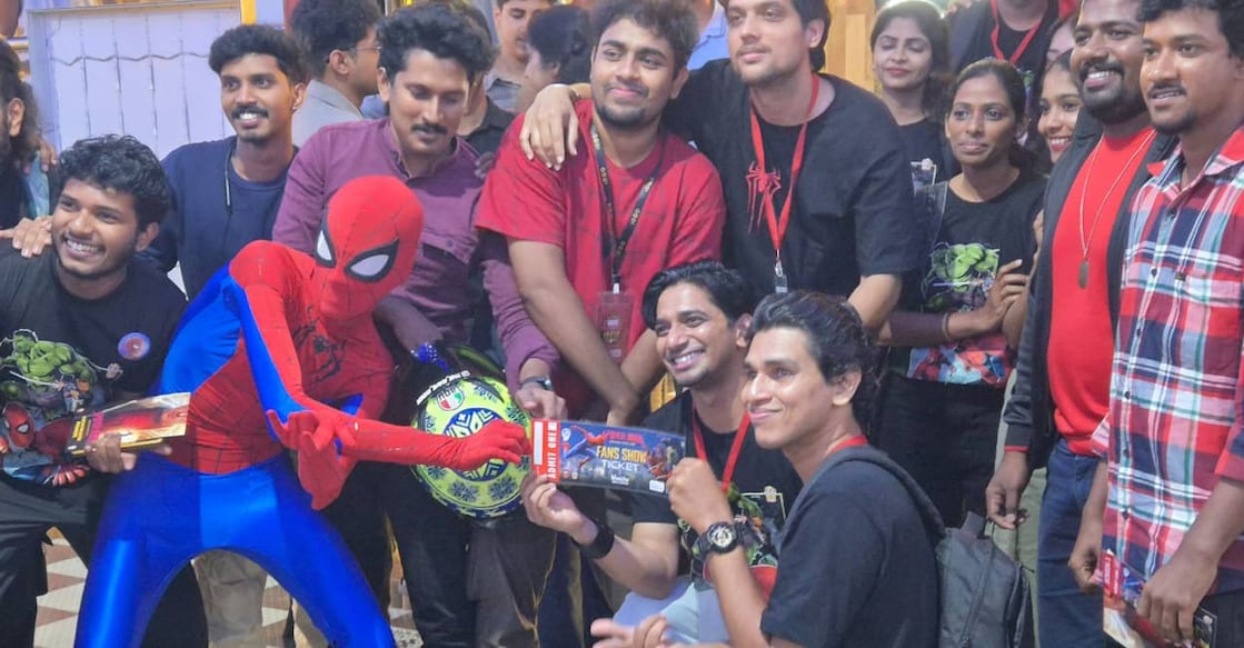Antony Emmanuel showcasing the first ticket signed by Tom Holland while posing with other Marvel fans in Kochi. Photo: Onmanorama