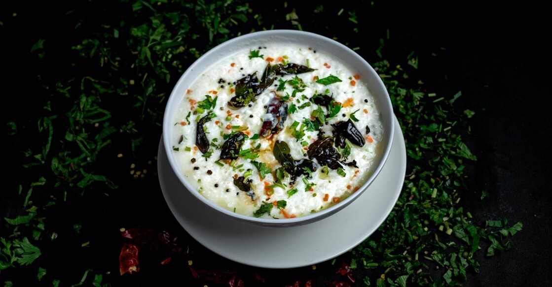 A bowl of curd rice topped with sizzling mustard seeds and curry leaves. Photo: Shutterstock/CleoArtStudioAndDesigns