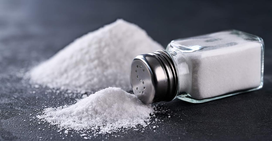 Salt shaker and a pile of spilled salt crystals. Photo: Shutterstock/itor
