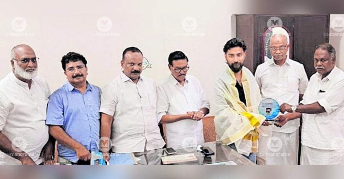 Punnayoor Panchayat President T V Surendran felicitates Life Care ambulance driver Afsal. Photo: Special Arrangement.