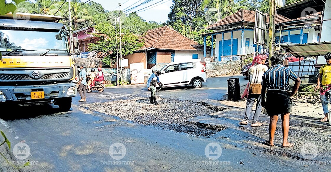 PWD workers re-tarring the pothole at Karinkallumoozhy Junction as a Taurus truck loaded with stones passes by. Photo: Manorama