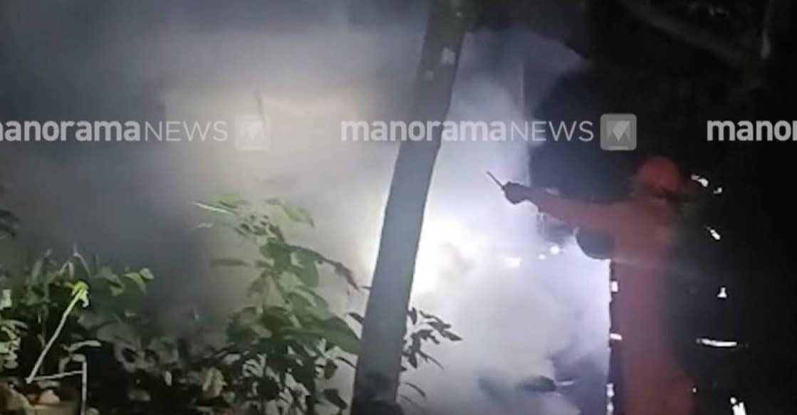 Fireman tries to douse the fire at the house in Idukki. Photo: Screengrab/Manorama News