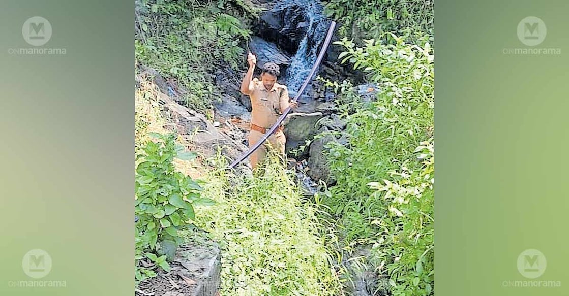 A Forest Department official dismantles a pipe set up to wash vehicles at a waterfall in Nadukani Ghat. Photo: Special arrangement