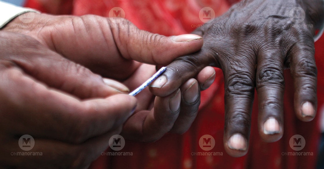An election official applies indelible ink to a voter's finger. File photo: Manorama