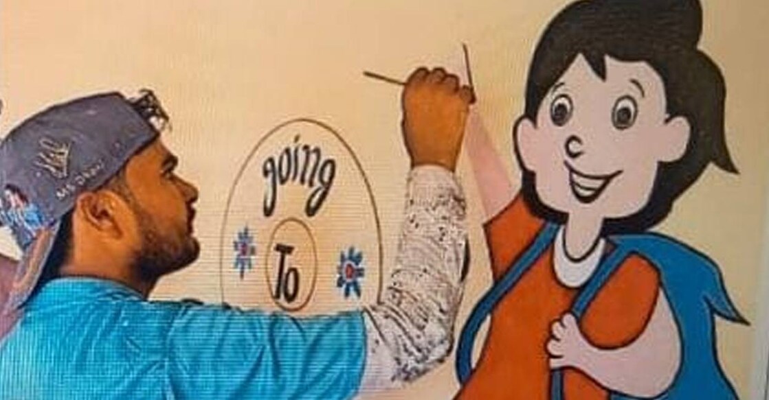 Afsar Ali painting the school wall. Photo: Special arrangement. 