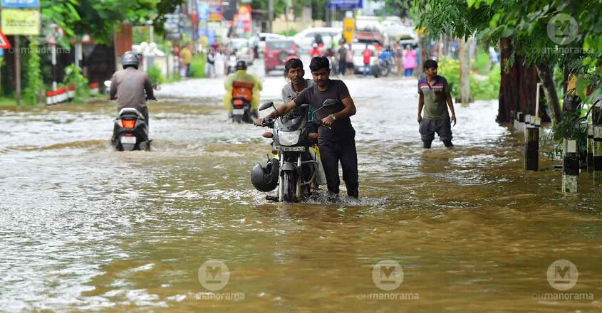 A man navigates through a waterlogged road in Kerala. Photo: Manorama