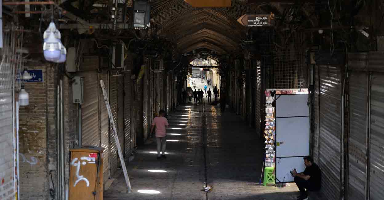 IRAN-ISRAEL-CONFLICT People walk past closed shops in Tehran's Grand Bazaar as fighting between Israel and Iran entered a fourth day on June 16, 2025. Photo: AFP/Atta Kenare