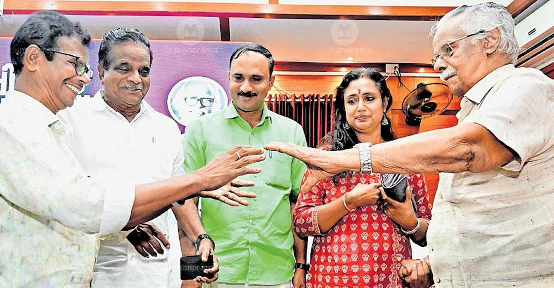 Actor Indrans welcomes writer T Padmanabhan to the venue of the People’s Award for Libraries and Library Workers, instituted by the People’s Mission for Social Development. District Panchayat Vice President Binoy Kurien, ADM Kalabhasker, and T K Govindan are also seen. Photo: Manorama