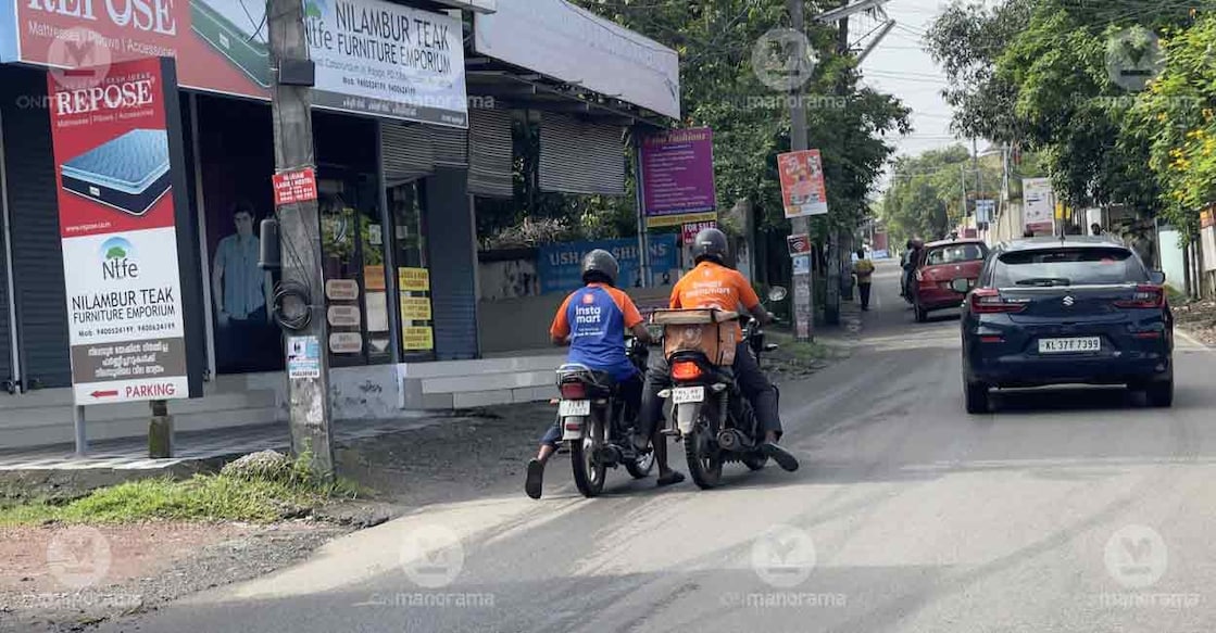 Instant grocery delivery guy gets support from a fellow mate as his bike runs out of fuel. A scene from north Kalamassery. Photo: Onmanorama