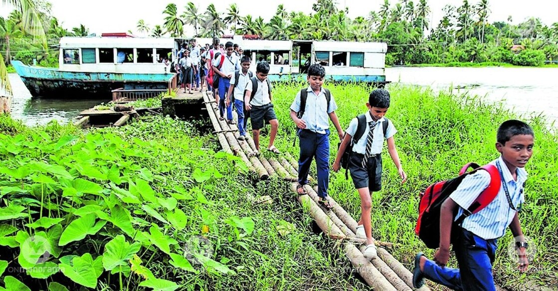 School students use the temporary bridge at the boat jetty. Photo: Manorama