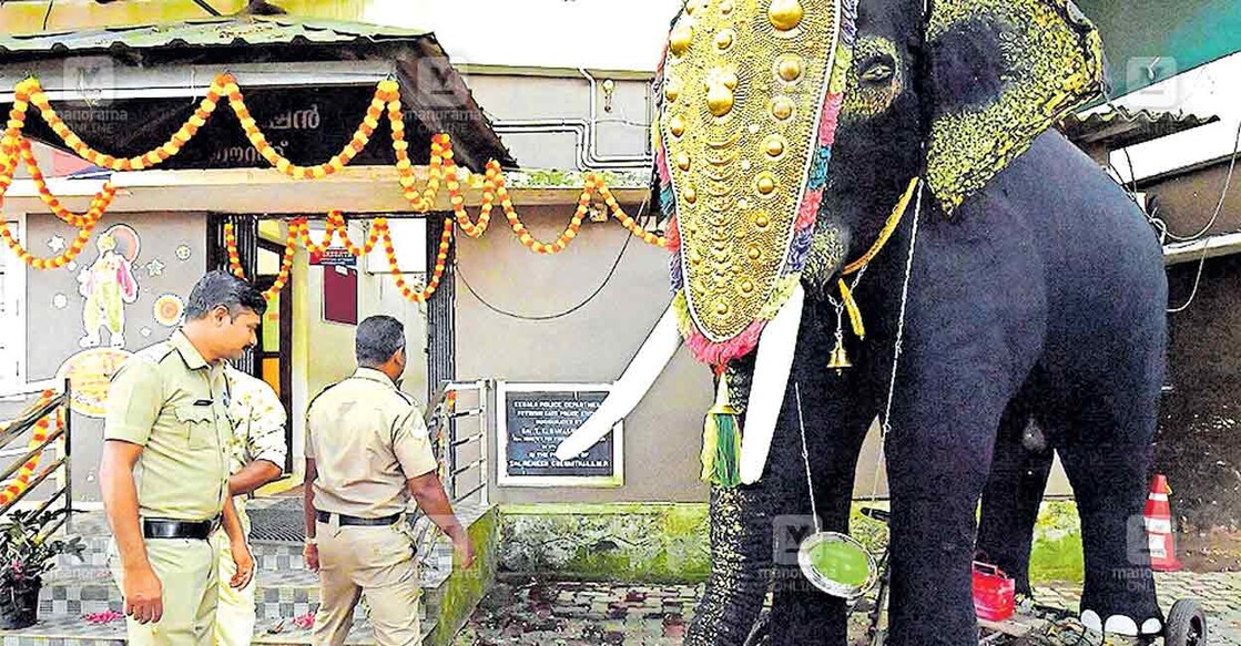 A scene from Kottayam East Police Station, where officers curiously watch the electric elephant brought as part of the Onam celebrations. Photo: Manorama