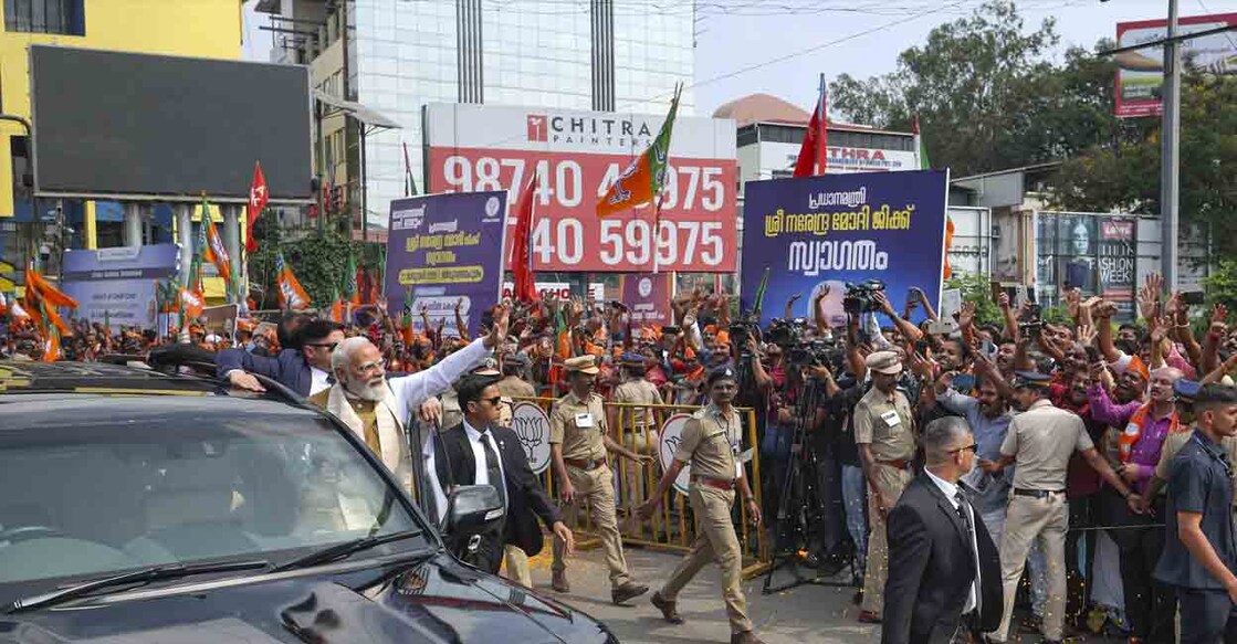Prime Minister Narendra Modi greets people during a roadshow upon his arrival, in Thiruvananthapuram, Kerala. Photo: PTI