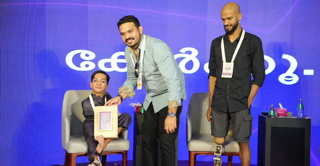 Swimmer and State Youth Icon awardee Aasim Velimanna with Dr Tom Joseph, Director – New Initiatives at Jain (Deemed-to-be University). Syam Kumar SS, world-record-holding skydiver, is also present. Photo: Special Arrangement