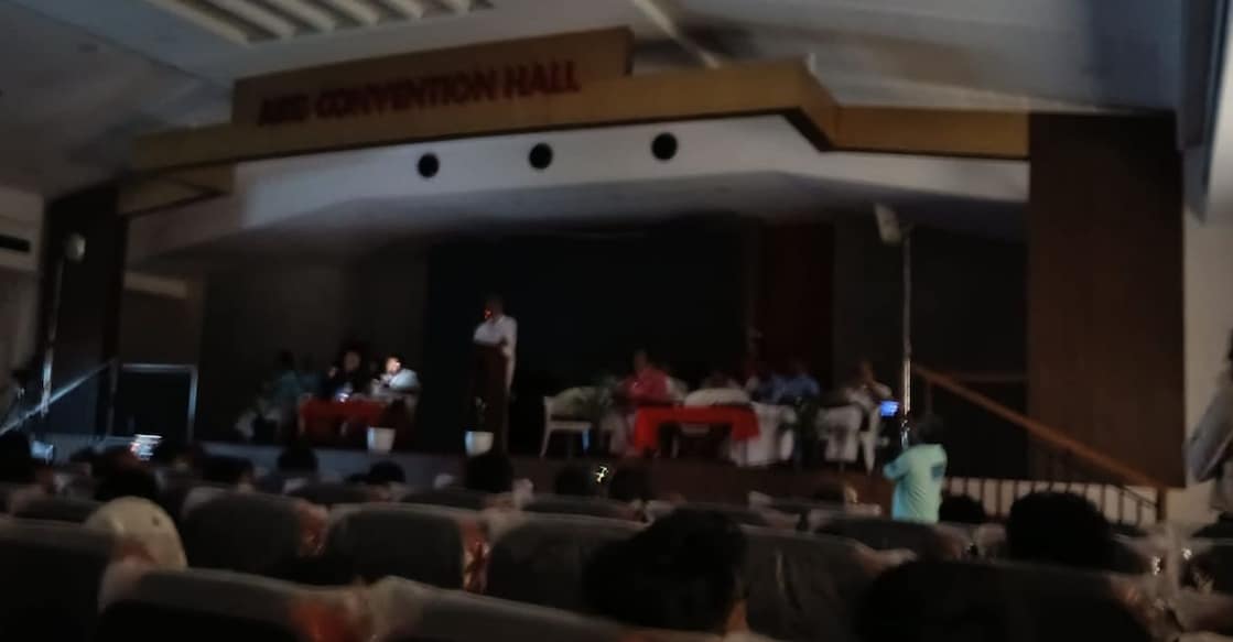 CPM Politburo member A Vijayaraghavan waits for the generator to kick in after a power cut plunges the AKG Convention Hall into darkness during his address in Kasaragod on Thursday. Photo: Special Arrangement. 