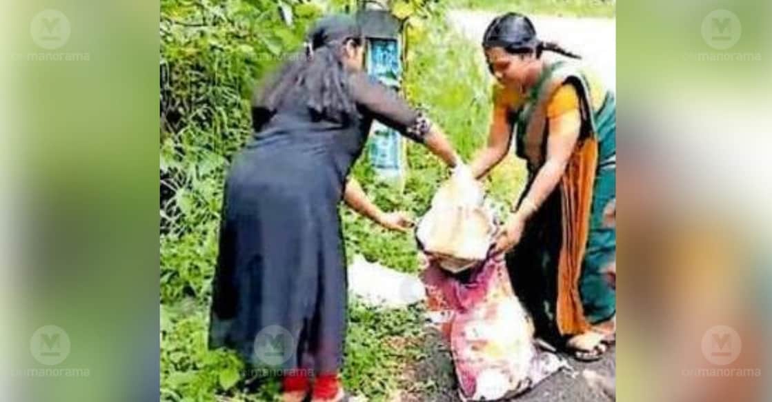 Panchayat members Swapna Prince and Sandhya Shibu clear waste dumped along the road near the Peethikeswaram Shiva Temple in Pengamuck. photo: Special arrangement