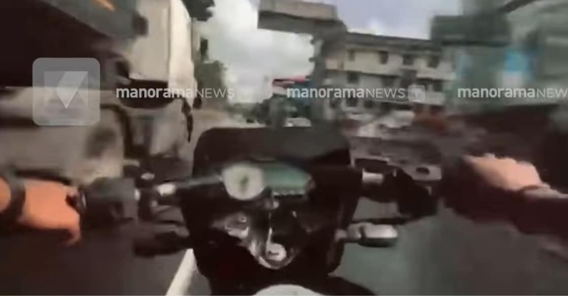 A screengrab showing the student riding a bike on a busy road. Photo: Manorama News