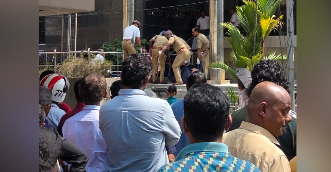 Locals look on as police remove the body of a man from in front of a jewellery shop in Kochi. Photo: Special arrangement
