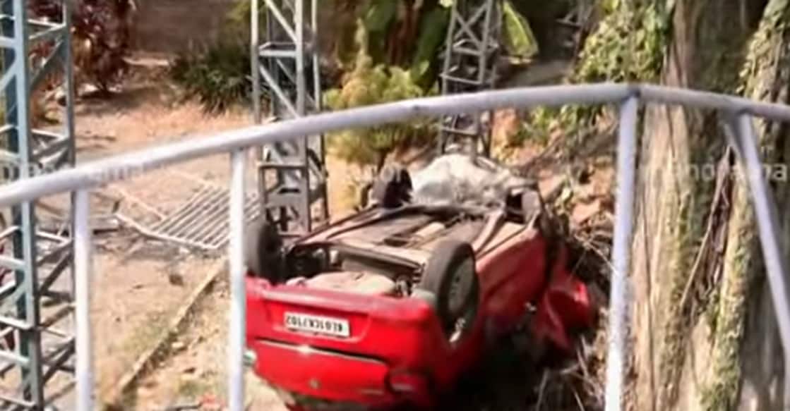 The car broke through the compound railing of a nearby house and plunged down a slope, overturning on impact. Photo: Manorama News