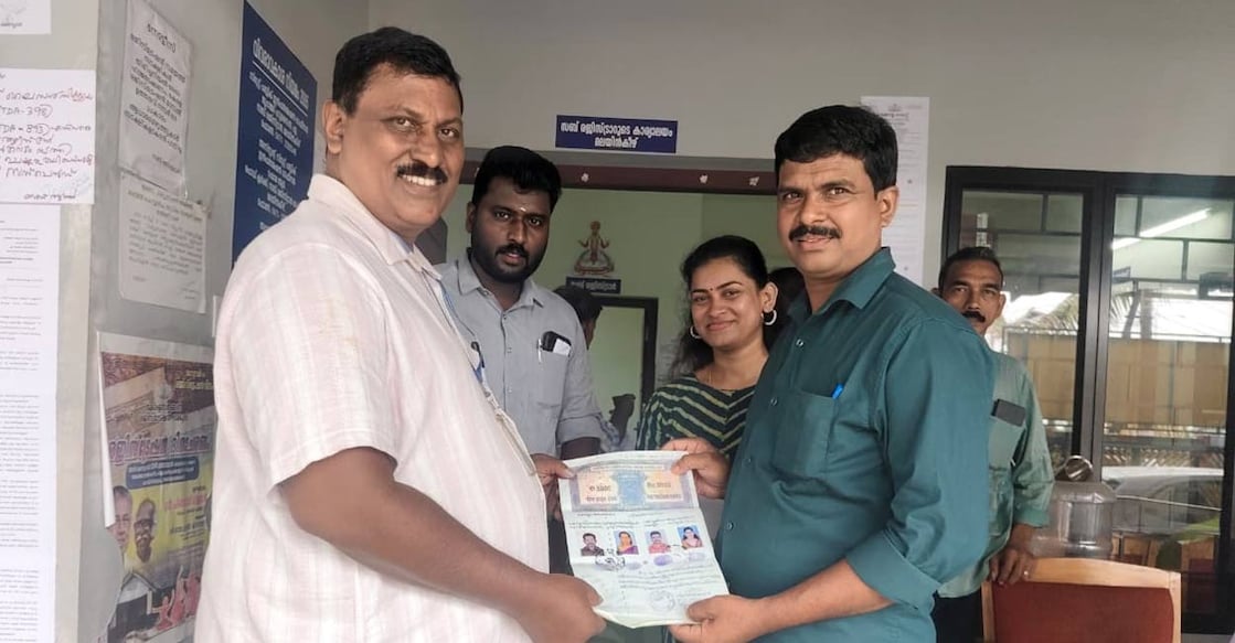 M Aji (first from right) handing over the documents to the panchayat secretary (first from left). Photo: Special Arrangement. 