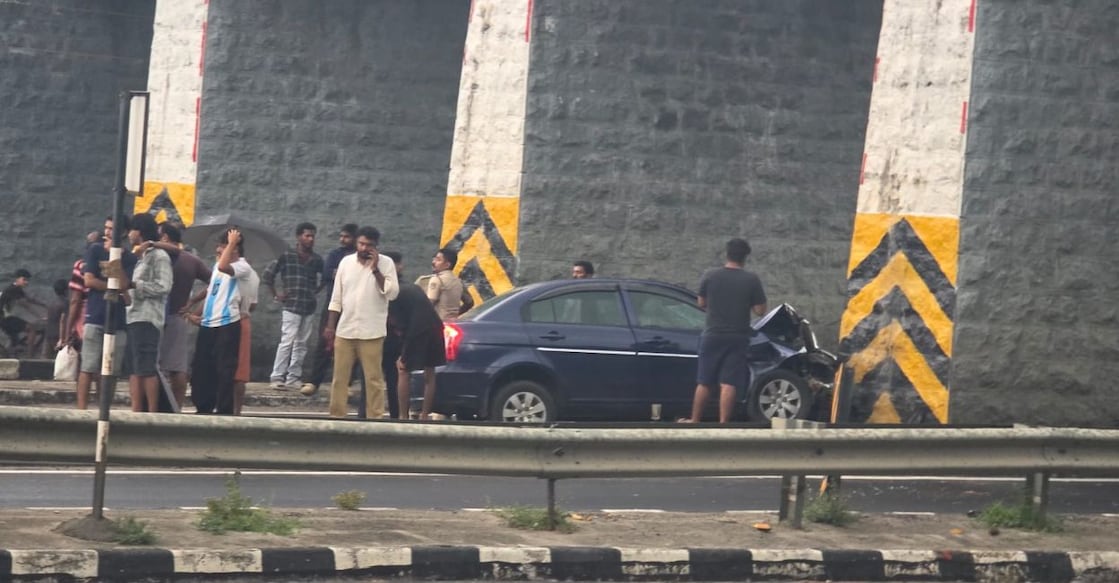 People gather at the spot where the car crashed into the pillar. Photo: Special Arrangement