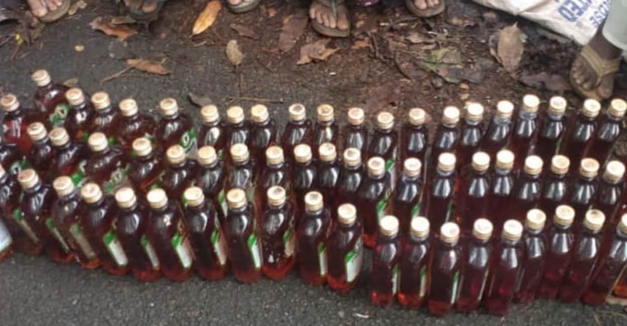 The 66 bottles of IMFL hidden inside bushes near Thiruvali recovered by women workers under the rural employment guarantee scheme. Photo: Special Arrangement