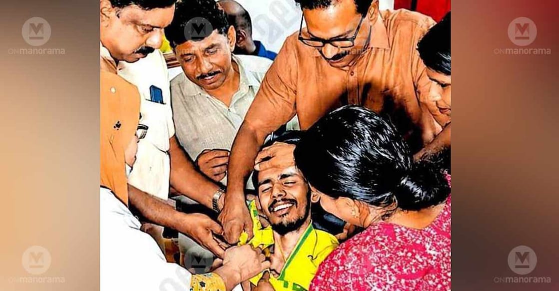 Akshay's mother, Jaya, helps him wear a Brazil jersey as friends and volunteers look on. Photo: Special arrangement