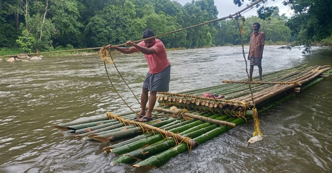 People of the Punchakolli tribal colony cross the Punnappuzha river aboard a raft they built themselves. Photo: Special Arrangement. 