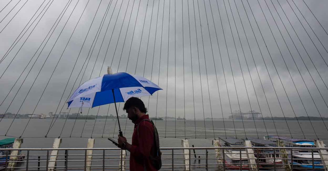 A man covers himself during rainfall as monsoon arrives, at Marine Drive, in Kochi, Kerala, Friday, June 5, 2026. Photo: PTi