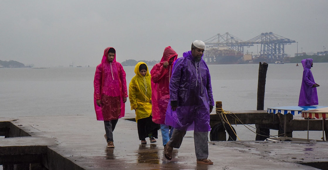 People cover themselves during rainfall as monsoon arrives, at Marine Drive, in Kochi, Kerala, Friday, June 5, 2026. Photo: PTI