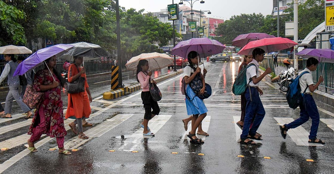 People cover themselves and cross a road during rainfall as monsoon arrives, in Kochi, Kerala, Friday, June 5, 2026. Photo: PTI