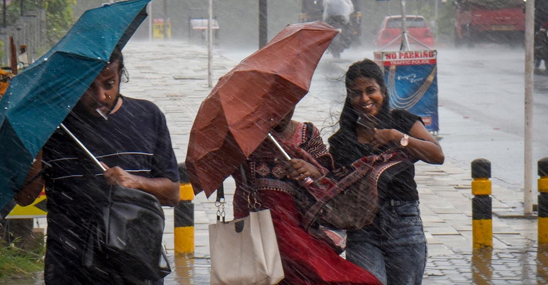 People cover themselves amid rain at Kochi, in Ernakulam district, Thursday, June 4, 2026. Photo: PTI