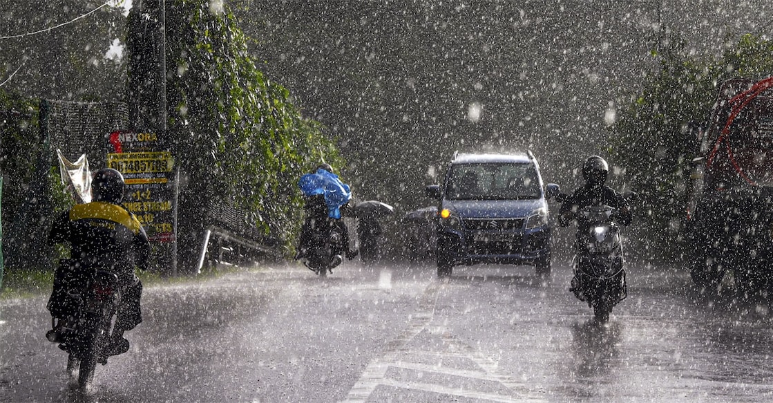 Commuters move along a street during rainfall. Representational Image: PTI