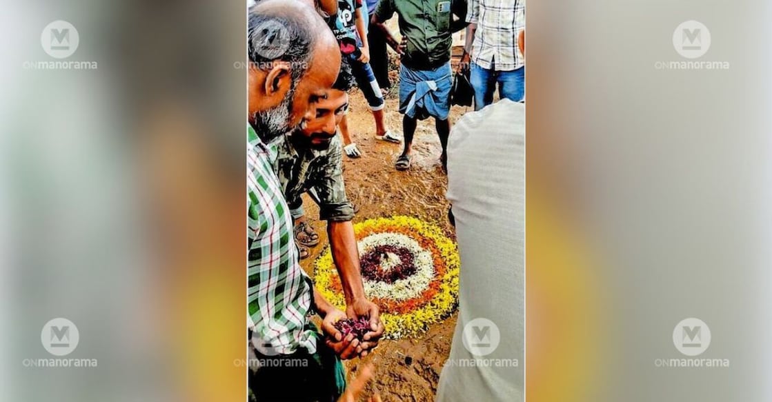 Pulpara residents, protesting the dilapidated and mud-filled roads of Kalpetta township, fashioned a pookkalam (floral design) directly in the muck. Photo: Special Arrangement.