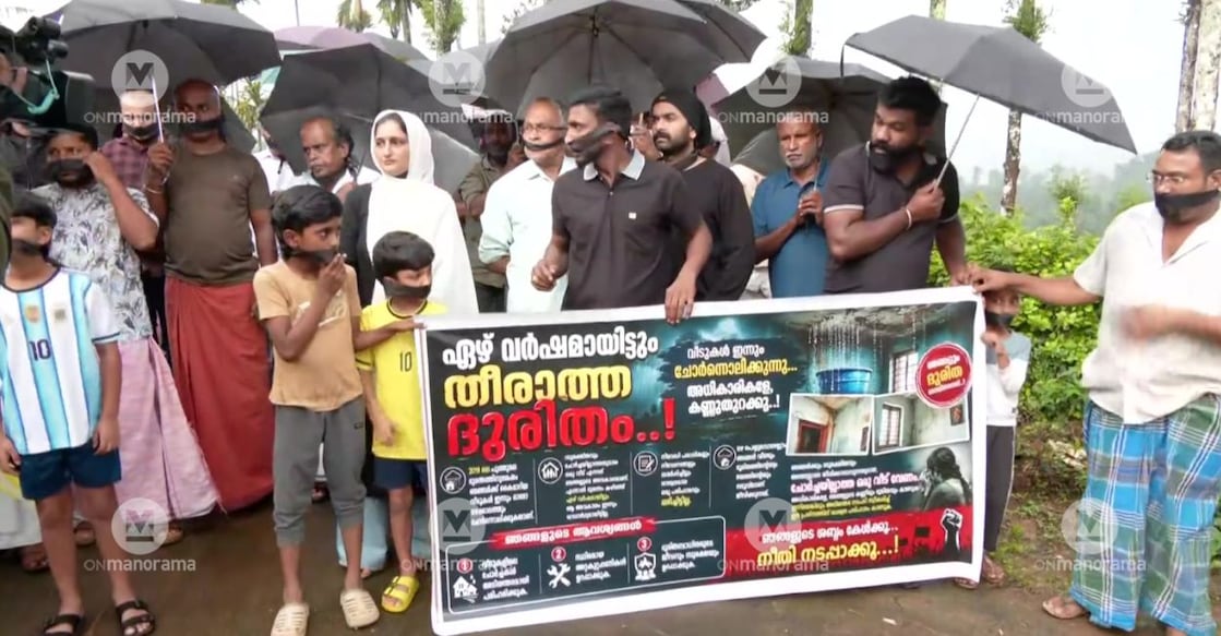 Puthumala disaster survivors stand together in silent protest, mouths covered, demanding action on unresolved housing issues. Photo: Special Arrangement.
