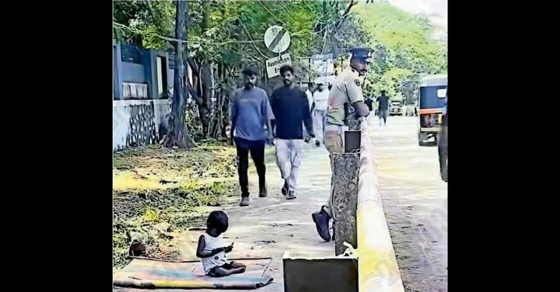 In Karyavattom, Thiruvananthapuram, R. Sabir, a police officer who arrived for duty from a police camp, shows a cartoon on his mobile phone to a child sitting by the roadside near the cricket match venue.