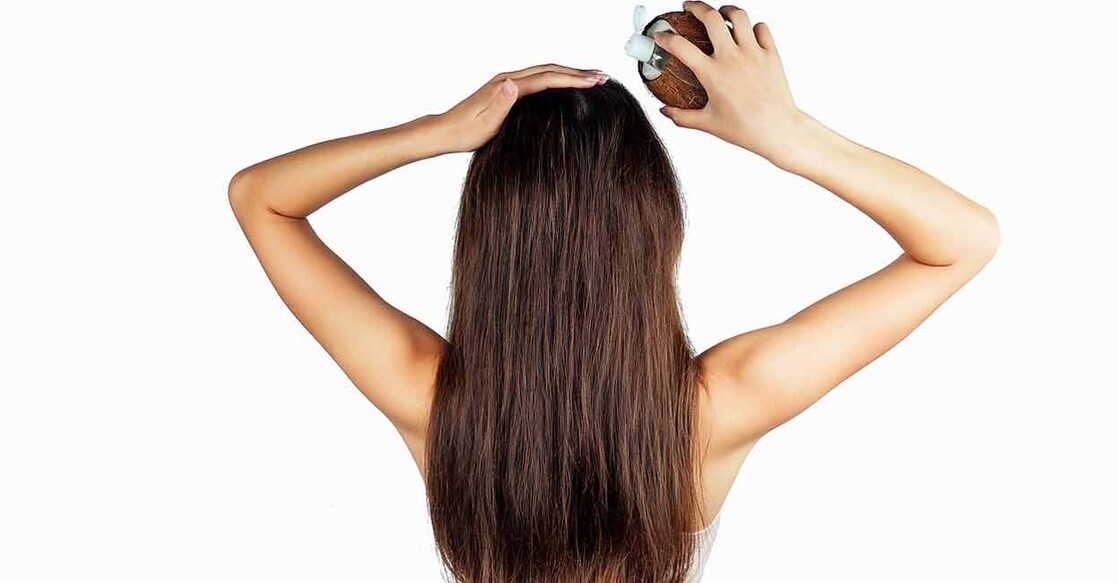 Using coconut oil sparingly on your scalp helps prevent damaging effects. Photo: iStock/IURII KRASILNIKOV
