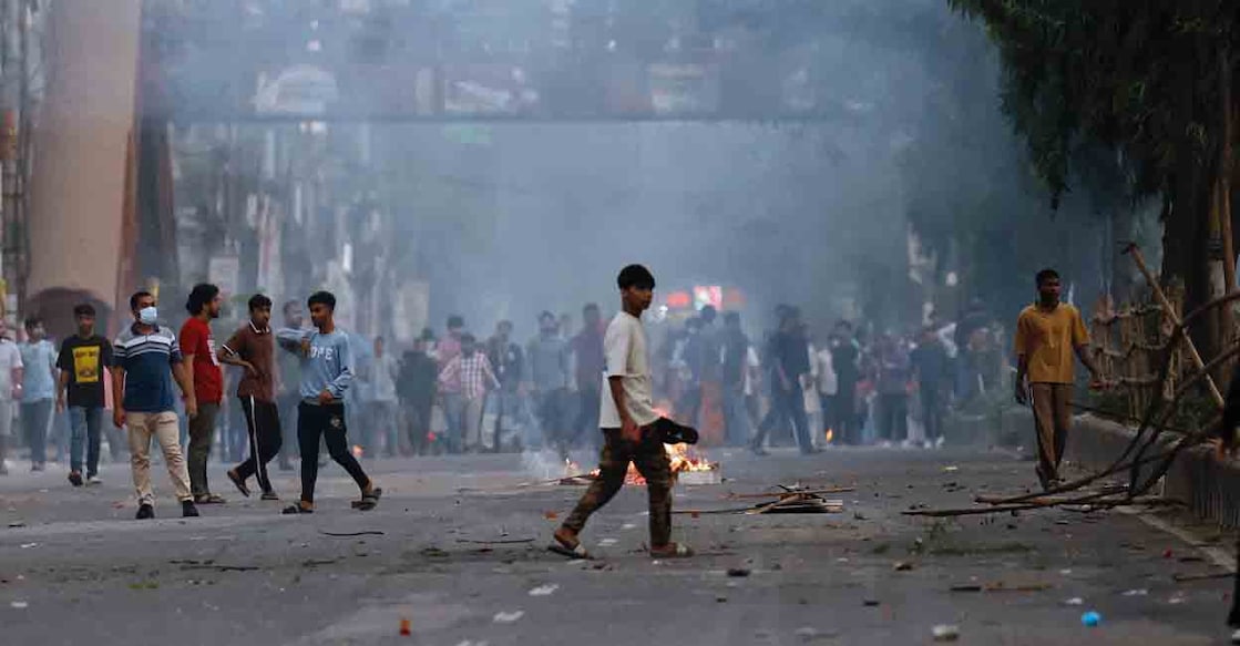 Anti-Hasina demonstrators walk near fire set by them on the streets during a clash after the verdict on cases against the ousted Prime Minister Sheikh Hasina, after a Bangladeshi court sentenced ousted Prime Minister Sheikh Hasina to death, finding her guilty of ordering a deadly crackdown on a student-led uprising last year, in Dhaka, Bangladesh, November 17, 2025. REUTERS/Mohammad Ponir Hossain