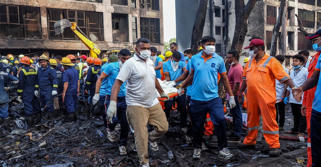 Rescue officials carry a victim's body at the site. Photo: Sam PANTHAKY / AFP