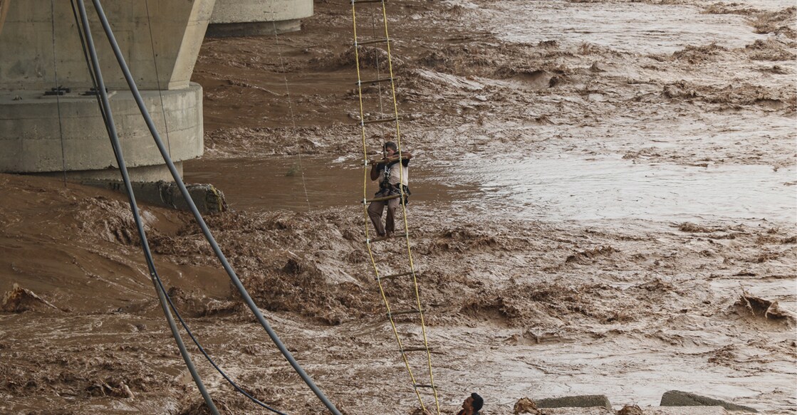 jammu-rains A State Disaster Response Force (SDRF) team rescues a man stuck in the middle of the Tawi River after a flash flood caused by heavy rainfall in Jammu. Photo: PTI