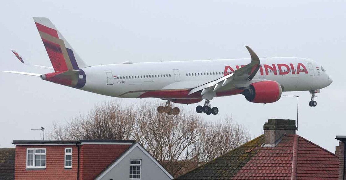 FILE PHOTO: An Air India passenger plane flies near houses as it makes its landing approach to Heathrow Airport in west London, Britain, January 28, 2025.  REUTERS/Toby Melville/File Photo