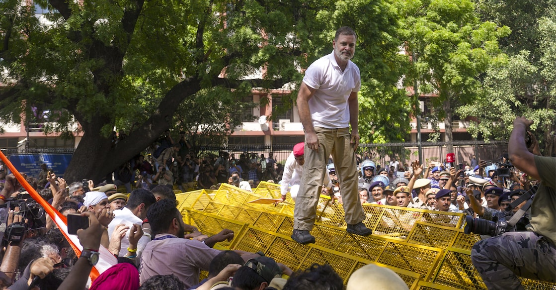 Leader of Opposition in the Lok Sabha Rahul Gandhi climbs atop police barricades after being stopped by security personnel during a protest march from Parliament towards the Election Commission of India (ECI) office. Photo: PTI