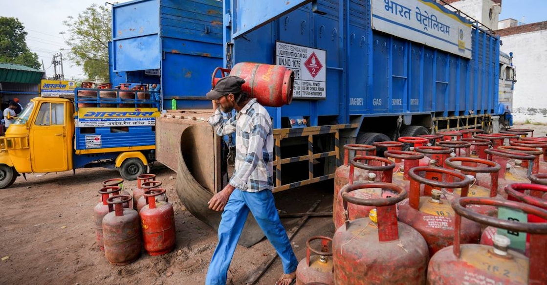 A worker carries a LPG cylinder at a distribution centre amid fuel shortages in the wake of the ongoing West Asia conflict, in Amritsar. Photo: PTI