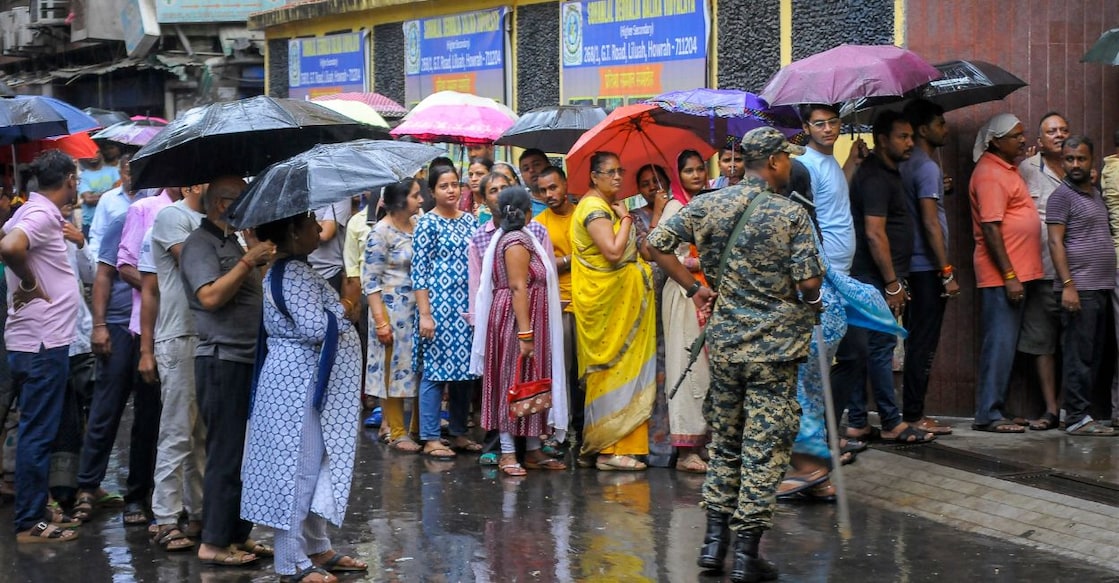 People waiting amid rain before casting their votes in the second and final phase of the West Bengal Assembly elections. Photo: PTI
