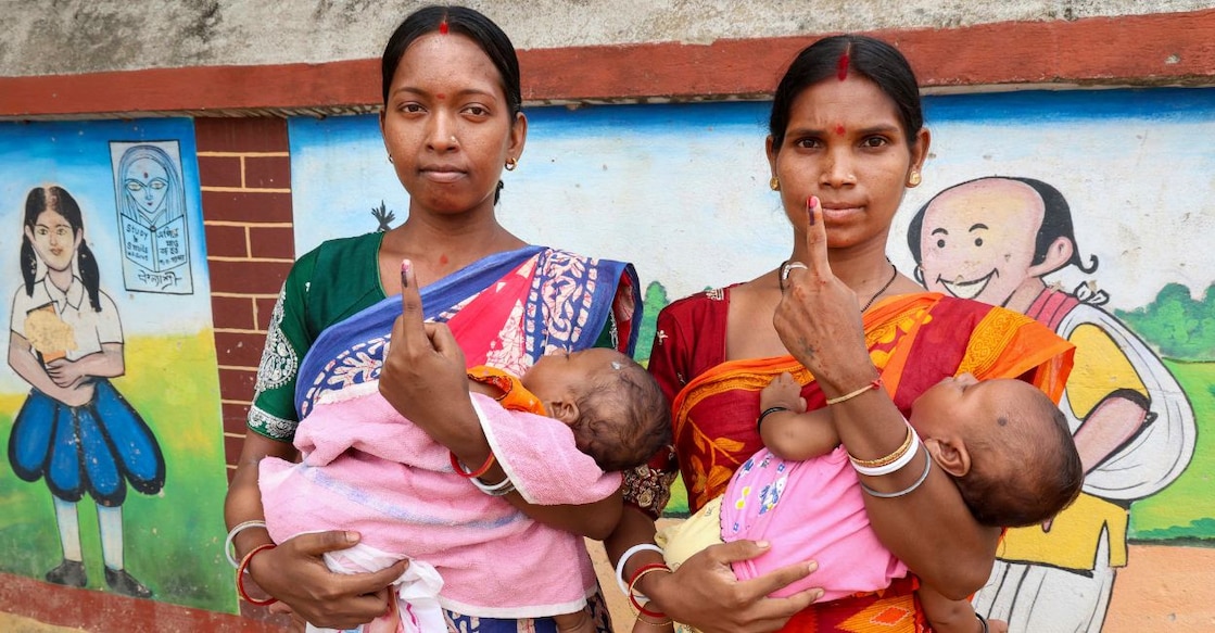 Women from the tribal community show their ink-marked fingers after casting their votes in the second and final phase of the West Bengal Assembly elections. Photo: PTI