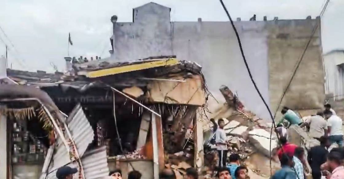 People gather after a four-storey building collapsed, trapping at least six persons in the debris, at Kotma town, in Anuppur district, Madhya Pradesh, Photo: PTI