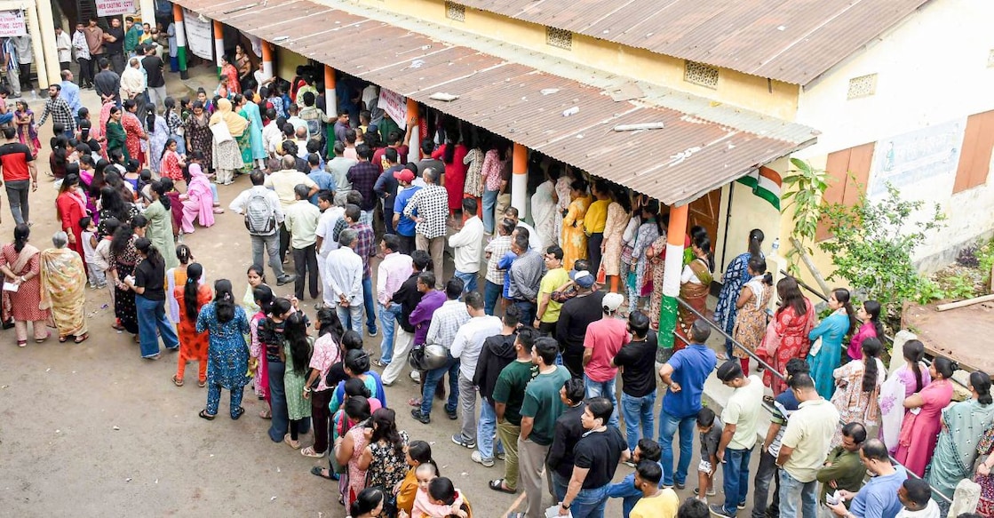 People wait in queues before casting their votes in the Assam Assembly elections, at a polling station in Guwahati. Photo: PTI