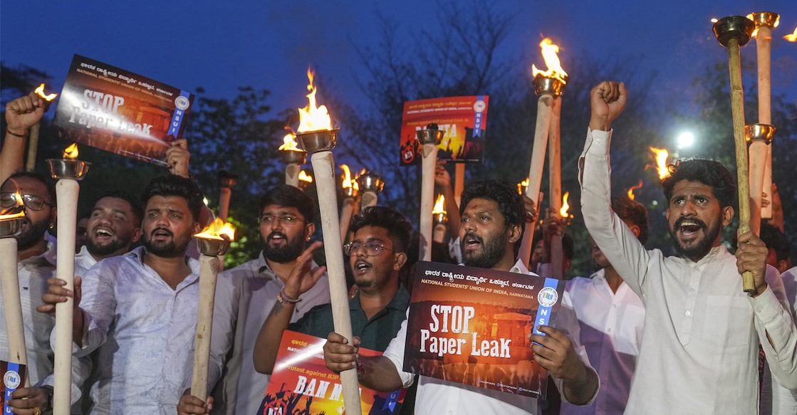 Members of the National Students' Union of India (NSUI) hold torches and placards as they raise slogans during a protest against the cancellation of NEET-UG 2026 over a suspected paper leak. Photo: PTI
