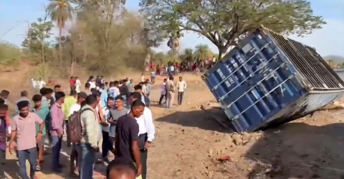 People gather near the overturned vehicles after a tempo carrying guests to an engagement ceremony collided with a container truck on the Mumbai-Ahmedabad Highway in Palghar district, Maharashtra. Photo: PTI