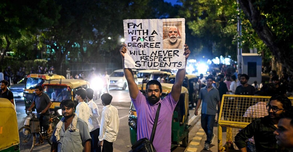 A Cockroach Janta Party (CJP) supporter holds a placard at Connaught Place in New Delhi on July 24, 2026, in solidarity with the ongoing protest at Jantar Mantar demanding the resignation of the country's Education Minister Dharmendra Pradhan over alleged NEET examination irregularities. Photo: PTI.