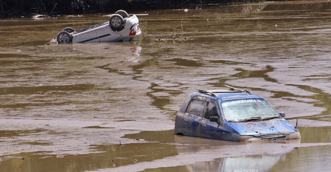 Cars lie partially submerged in mud and silt washed along floodwater of the swollen Dikhow River after heavy monsoon rainfall, at Bihubar, in Sivasagar district, Assam. Photo: PTI 